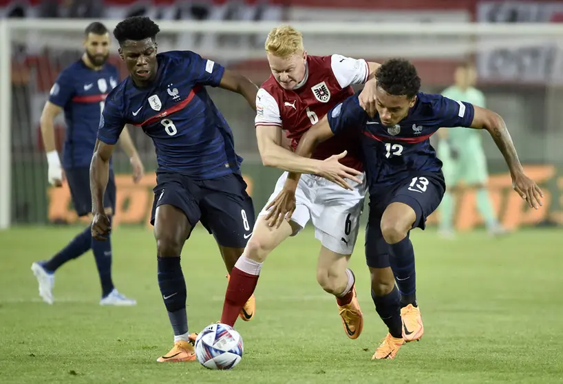 10 June 2022, Austria, Vienna: France's Aurelien Tchouameni (L) and Boubacar Kamara battle for the ball with Austria's Nicolas Seiwald battle for the ball during the UEFA Nations League Group A soccer match between Austria and France at Ernst Happel Stadium. Photo: Hans Punz/APA/dpa.