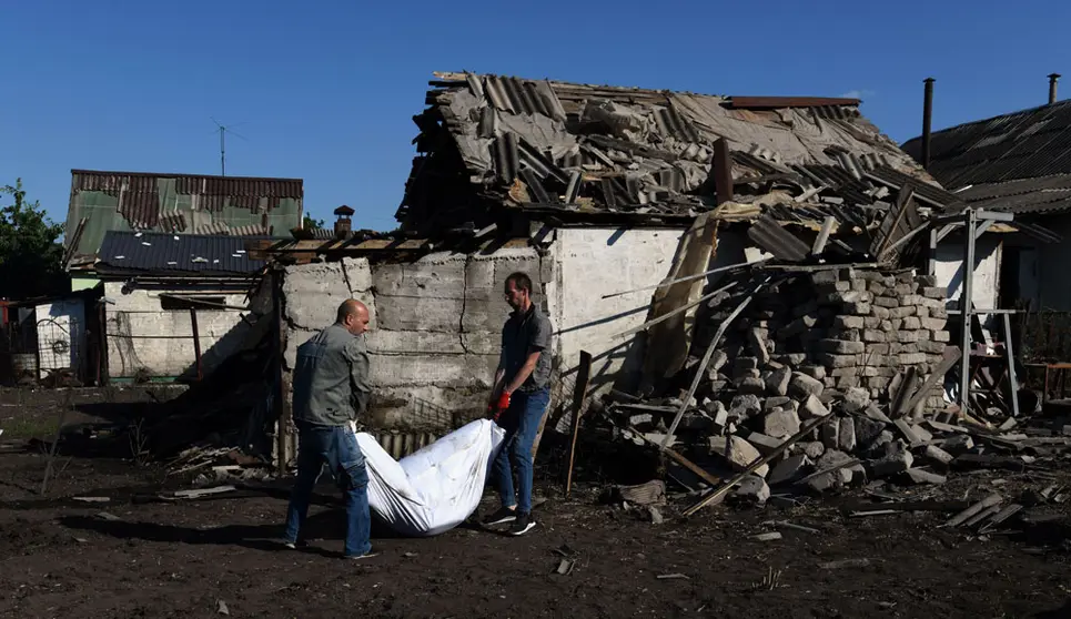 21 June 2022, Ukraine, Kharkiv: People carry the body of Raisa Kozakova, 85 years old, after she was killed when a shell hit her home while she was picking peas. Photo: Carol Guzy/ZUMA Press Wire/dpa.