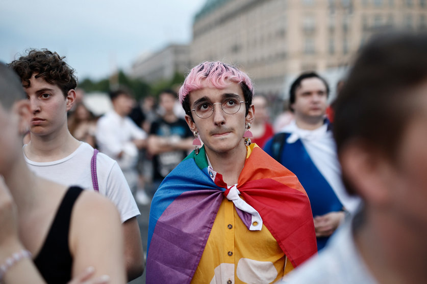 25 June 2022, Berlin: People commemorate the victims of the attack in Oslo at the Brandenburg Gate. On Saturday night a shooting incident in Oslo targeted a gay bar, leaving two people dead and 21 others injured. Photo: Carsten Koall/dpa.