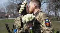 Kiev (Ukraine): Members of the Kiev Territorial Defense, Anastasiia Mokhina (L) and Viacheslav Hohlyuk kiss each other after they got married under the laws of martial law in Ukraine. Photo: Mykhaylo Palinchak/dpa.