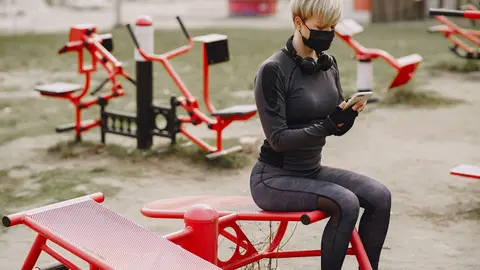 Woman-face-mask-gymnastics-coronavirus-smartphone