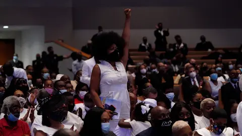 A woman raises her fist during the funeral service for African-American citizen George Floyd, who was killed on 25 May 2020 by a white policeman in the US city of Minneapolis, at the Fountain of Praise Church. Photo: David J. Phillip/POOL via Zuma/dpa