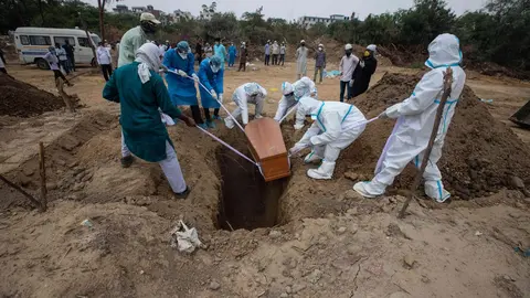 10 June 2020, India, New Delhi: Medical workers and relatives wearing personal protective equipment gear buried a person who died of coronavirus (Covid-19) at the Jadid Qabristan Ahle Islam graveyard. Photo: Vijay Pandey/ZUMA Wire/dpa