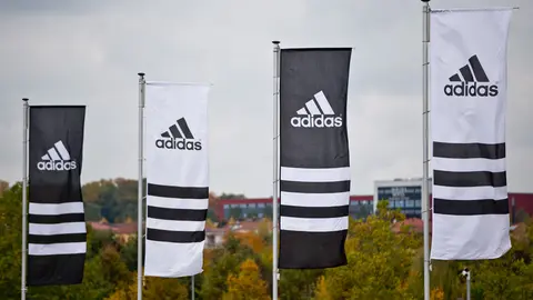 Flags with the logos of the sporting goods manufacturer Adidas wave. Adidas&#39; executive board member for global human resources, Karen Parkin, has stepped down after being accused of racism. Photo: Daniel Karmann/dpa