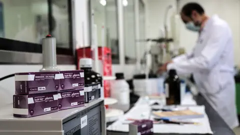 Packs containing vials of Remdesivir, a broad-spectrum antiviral medication approved as a specific treatment for COVID-19, lie next to an employee of Egyptian pharmaceutical company Eva Pharma at the company's factory, which started producing the drug this week with a production capacity of up to 1.5 million doses per month. The European Commission says it has approved the use of the medication remdesivir to treat severe cases of Covid-19 in the European Union. Photo: Fadel Dawood/dpa
