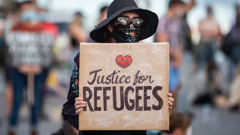 Brisbane: A protester holds a placard as she takes part in a "Free The Refugees" rally at Kangaroo Point against the dismissal of asylum seekers. Photo: Glenn Hunt/AAP/dpa