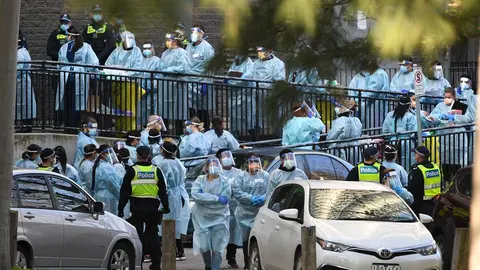 Australia, Melbourne: Healthcare workers prepare to enter a public housing tower in North Melbourne, which locked down in an effort to slow the spread of coronavirus. Photo: James Ross/AAP/dpa