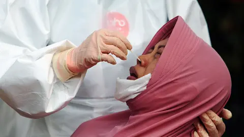 Indonesia, Surabaya: A medical worker takes a swab from a woman at a test station for coronavirus (Covid-19). Photo: Budiono/Sijori Images via ZUMA Wire/dpa