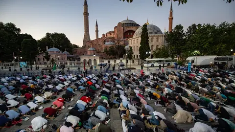 10 July 2020, Turkey, Istanbul: Muslims perform evening prayers in front of the Hagia Sophia museum, on the day of the court decision that revoked its status as a museum to be turned into a mosque. The former Istanbul museum will hold Muslim prayers today for the first time since it was reconverted into a mosque by a presidential decree on July 10. Photo: Yasin Akgul/dpa.