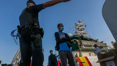 Spain, Malaga: An officer guides a group of immigrants after arriving at the coast of Almeria in Malaga. Photo: dpa.