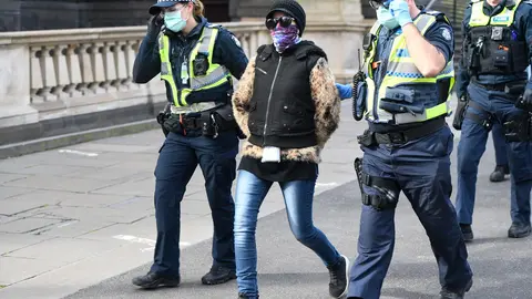 09 August 2020, Australia, Melbourne: Policemen detain a woman during an anti-lockdown protest after the police warned people planning to attend a Melbourne protest that it’s a breach of COVID-19 restrictions. Photo: Erik Anderson/dpa.