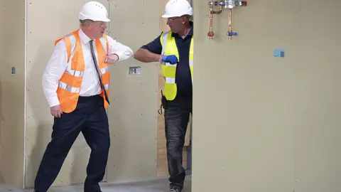 11 August 2020, England, Hereford: UK Prime Minister Boris Johnson (L) greets a worker with an elbow bump during a visit to the construction site of Hereford County Hospital. Photo: Matthew Horwood/dpa.