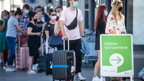 16 August 2020, Baden-Wuerttemberg, Stuttgart: Passengers wait in a long queue in front of a coronavirus test centre at Stuttgart Airport. Photo: Christoph Schmidt/dpa