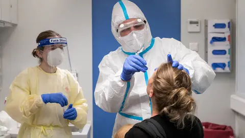 13 August 2020, Baden-Wuerttemberg, Stuttgart: A traveler (R) who has been in Switzerland gets tested by medic at a coronavirus testing center set to allow travellers returning from risk areas to take COVID-19 tests at the main railway station in Stuttgart. Photo: Marijan Murat/dpa.