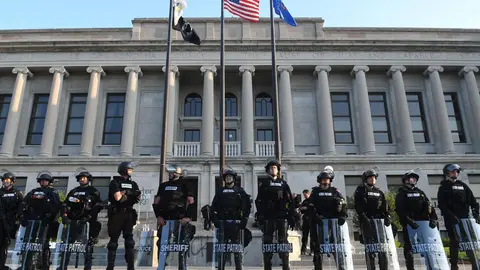 24 August 2020, US, Kenosha: Police officers guard the Kenosha County Court House, after a demonstration following the shooting of Jacob Blake, an African-American man, by a white police officer the day before. Photo: Mark Hertzberg/dpa.