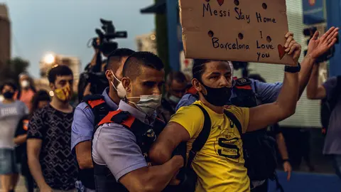 A policeman arrests a Barcelona fan during a protest in front of the Camp Nou stadium against club president Josep Maria Bartomeu after Argentina&#39;s Lionel Messi asked the club to leave after almost 20 years among its ranks. Photo: Matthias Oesterle/dpa.