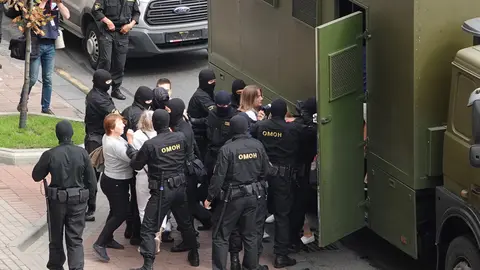 30 August 2020, Belarus, Minsk: Riot police arrest demonstrators into a prisoner transport vehicle, as thousands of people take part in mass demonstration against President Alexander Lukashenko. Photo: Ulf Mauder/dpa.