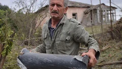 HANDOUT - 28 September 2020, Azerbaijan, Martuni: A man holds remains of a rocket shell, fired at the Martuni town in the self-proclaimed Republic of Nagorno-Karabakh, also known as Artsakh. Heavy fighting has broken out in the disputed Nagorno-Karabakh region in the southern Caucasus between neighbouring Azerbaijan and Armenia on Sunday. Photo: -/Armenian Foreign Ministry/dpa.