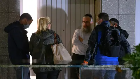 04 October 2020, Hamburg: Shlomo Bistritzky (C), state rabbi of Hamburg, talks to investigators at the synagogue near where a 29-year-old man struck a 26-year-old Jewish student with a blunt object. Photo: Jonas Walzberg/dpa.