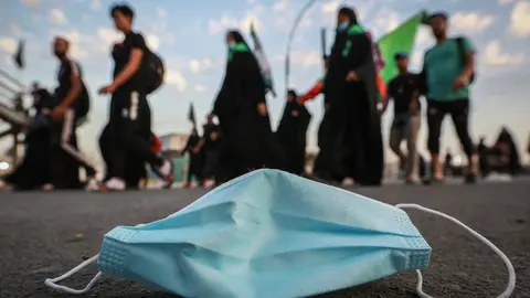 05 October 2020, Iraq, Karbala: A used face mask can be seen on the street during the Shia Muslims march from Baghdad to visit the Husayn Mosque in Karbala on the occasion of Arba'een, also known as Chehelom, a religious observance that occurs forty days after the Day of Ashura to commemorate the martyrdom of Husayn ibn Ali, the grandson of the Islamic Prophet Muhammad, who was killed on the 10th day of the month of Muharram, according to Islamic calendar. Photo: Ameer Al Mohammedaw/dpa.