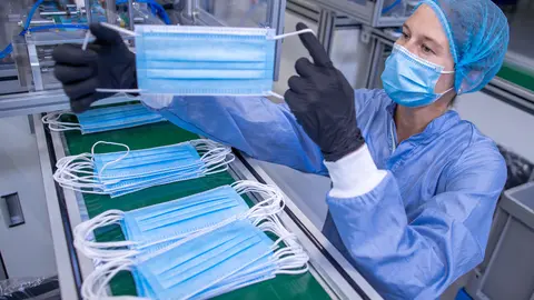 17 September 2020, Mecklenburg-Western Pomerania, Laage: An employee checks the production of protective masks at the medical technology company BM Bioscience Technology. Photo: Jens Büttner/dpa.