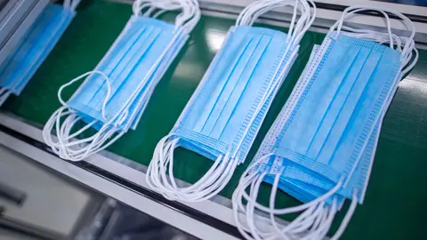 17 September 2020, Mecklenburg-Western Pomerania, Laage: Protective masks that have just been produced run over a conveyor belt at the medical technology company BM Bioscience Technology. Photo: Jens Büttner/dpa.