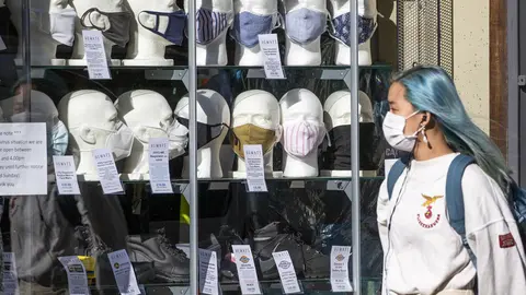22 September 2020, Scotland, Edinburgh: A woman wearing a protective face mask walks past a shop selling masks in Edinburgh city centre, after First Minister Nicola Sturgeon announced a range of new measures to combat the rise in coronavirus cases in Scotland. Photo: Jane Barlow/dpa.