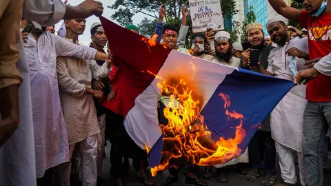 30 October 2020, Bangladesh, Dhaka: Bangladeshi Muslim protesters burn a French flag during a demonstration against French President Emmanuel Macron&#39;s comments on Islam&#39;s prophet Muhammad cartoons. Photo: Zabed Hasnain Chowdhury/dpa.