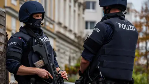 03 November 2020, Austria, Linz: Police officers stand guard in front of a building during a raid to arrest a man who might have a connection about last night terrorist attack which took the lives of several people. Photo: Werner Kerschbaummayr/dpa.