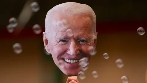 07 November 2020, US, Seattle: A person holds a picture of the US president-elect, Joe Biden, during celebrations in the street in Seattle after has won the election to become the US 46th president. Photo: David Ryder/dpa.