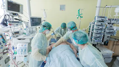 10 November 2020, North Rhine-Westphalia, Bonn: Medical staff care for a coronavirus patient who is on a respirator in an intensive care unit at the University Hospital in Bonn. Photo: Rolf Vennenbernd/dpa.