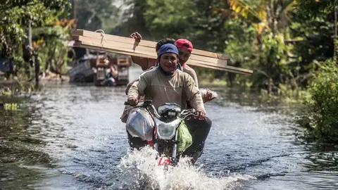 11 November 2020, Mexico, Nacajuca: Three men ride a motorcycle in a flooded street after heavy rains hit the Tabasco state. Photo: -/El Universal via ZUMA Wire/dpa