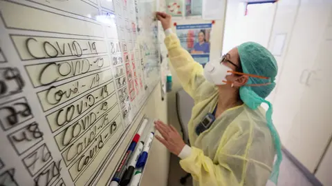 11 November 2020, Baden-Wuerttemberg, Stuttgart: Ayse Yeter, nurse and head of coronavirus (COVID-19) intensive care unit (ICU) at the Stuttgart Hospital, wipes the data of a patient discharged from the ICU from a whiteboard. Photo: Marijan Murat/dpa.