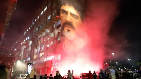 25 November 2020, Italy, Naples: Flares are lit as fans flock to Diego Maradona's mural in Naples. Argentina football great Diego Maradona has died at the age of 60, the Argentinian Football Association said on Wednesday. Photo: Fabio Sasso/LaPresse via ZUMA Press/dpa.
