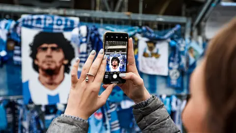 29 November 2020, Italy, Naples: A woman takes a photo by her cellular phone for the makeshift memorial which is dedicated to the memory of late Argentinian football legend Diego Maradona, outside the San Paolo stadium. Photo: Alessandro Garofalo/LaPresse via ZUMA Press/dpa