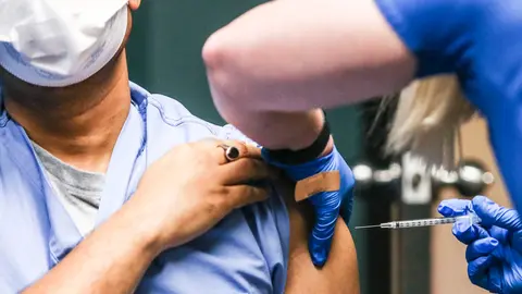 16 December 2020, US, Silvis: Piyush Singh (L) pediatrician receives one of the first coronavirus (COVID-19) vaccine at Genesis Medical Center. Photo: Jessica Gallagher/Dispatch Argus via ZUMA Wire/dpa
