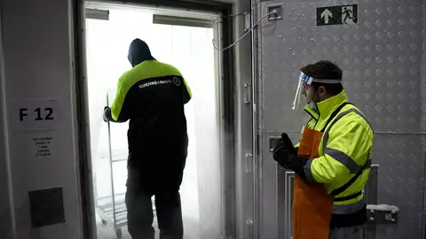HANDOUT - 26 December 2020, North Rhine-Westphalia, ---: Employees of logistics companies work on the first shipment of the Pfizer-BioNTech coronavirus vaccine which arrived at the central warehouse of North Rhine-Westphalia. The vaccine, which is filled into small vials, must be stored at minus 70 degrees. Photo: Mark Hermenau/Staatskanzlei des Landes Nordrhein-Westfalen/dpa - ATTENTION: editorial use only and only if the credit mentioned above is referenced in full
