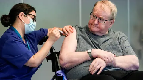 27 December 2020, Norway, Oslo: Nurse Maria Golding (l) vaccinates 67-year-old Svein Andersen with the Coronavirus vaccine from Biontech/Pfizer. Photo: Fredrik Hagen/NTB/dpa