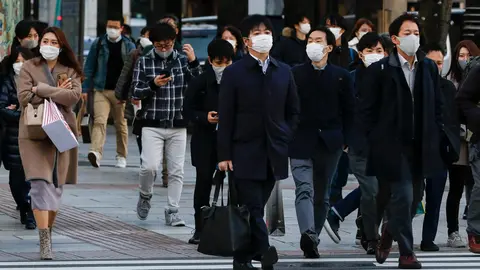 16 December 2020, Japan, Tokyo: People wearing face masks walk around the Ginza shopping district. Tokyo reached a new single-day record of 678 new coronavirus (COVID-19) cases on Wednesday. Photo: Rodrigo Reyes Marin/dpa.