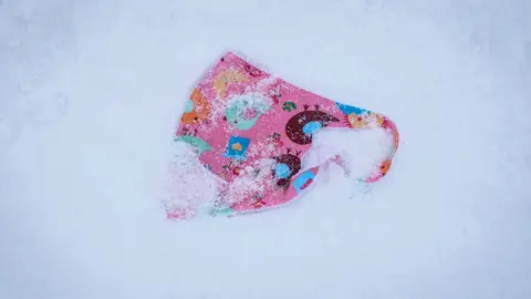 11 December 2020, Hessen, Grosser Feldberg: A patterned face mask lies in the snow on the summit plateau of the Grosser Feldberg mountain. Photo: Frank Rumpenhorst/dpa