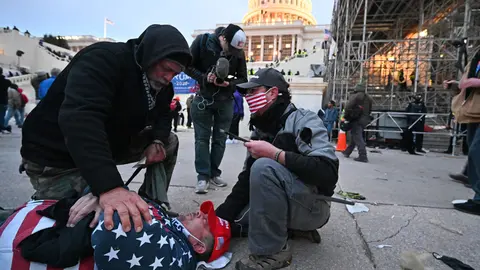 06 January 2021, US, Washington: A man lies on the ground after having been hit with a rubber bullet allegedly fired by the US Capitol Police as supporters of US President Donald Trump storm the US Capitol building where lawmakers were due to certify president-elect Joe Biden's win in the November election. Photo: Essdras M. Suarez/ZUMA Wire/dpa