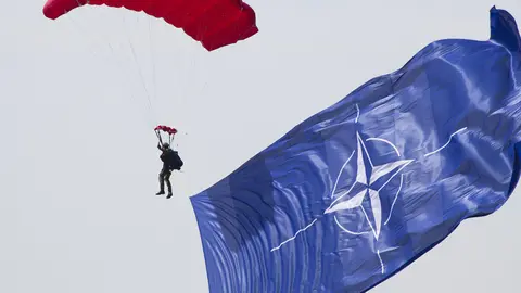 A paratrooper waves the NATO flag during a jump. Photo: Pixabay.
