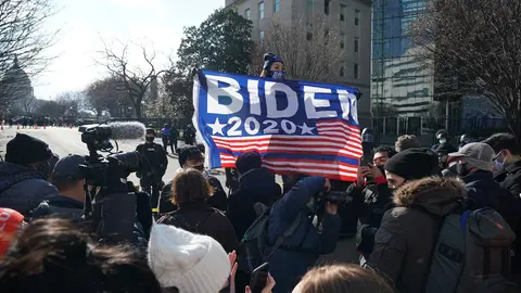20 January 2021, US, Washington: People wave a flag and celebrate during the President-elect Joe Biden inauguration as the 46th President of the United States. Photo: Bryan Smith/ZUMA Wire/dpa