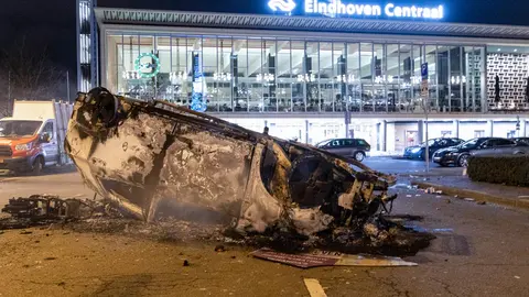 24 January 2021, Netherlands, Eindhoven: Debris of a burned out car can be seen in front of Eindhoven Central train station in the aftermath of a demonstration against the current coronavirus policy. Photo: Nik Oiko/SOPA Images via ZUMA Wire/dpa