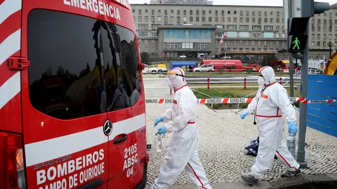 29 January 2021, Portugal, Lisbon: Health care workers in protective suits walk past an ambulance at the new triage center for coronavirus patients at Santa Maria Hospital. Photo: Pedro Fiuza/ZUMA Wire/dpa