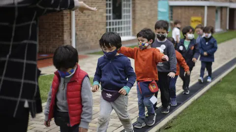 09 February 2021, Colombia, Bogota: A teacher tries to teach young children with masks on how to keep their distance from each other amid the Corona pandemic after partial attendance classes resumed in 907 schools in the Colombian capital. Photo: Alvaro Tavera/colprensa/dpa