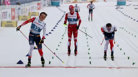 07 March 2021, Bavaria, Oberstdorf: Johannes Hoesflot Klaebo of Norway (L) crosses the finish line ahead of Emil Iversen of Norway (R) and Alexander Bolshunov from Russia during the men's 50 kilometre classical mass start event at the FIS Nordic World Ski Championships in Oberstdorf. Photo: Karl-Josef Hildenbrand/dpa