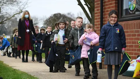 08 March 2021, United Kingdom, Shipdham: Children arrive at Thomas Bullock Church of England Primary Academy as pupils in England return to school for the first time in two months as part of the first stage of lockdown easing. Photo: Joe Giddens/PA Wire/dpa