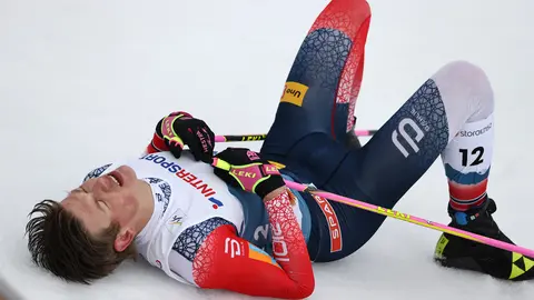 07 March 2021, Bavaria, Oberstdorf: Norway's Johannes Hoesflot Klaebo lies on teh ground after crossing the finish of the men's 50 kilometre classical mass start event at the FIS Nordic World Ski Championships in Oberstdorf. Photo: Daniel Karmann/dpa
