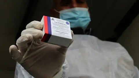 17 February 2021, Palestinian Territories, Rafah: A Palestinian health worker holds a pack of the Sputnik V COVID-19 vaccine. The Gaza Strip received its first batch of the Sputnik V COVID-19 vaccine on Wednesday. Photo: Ashraf Amra/APA Images via ZUMA Wire/dpa